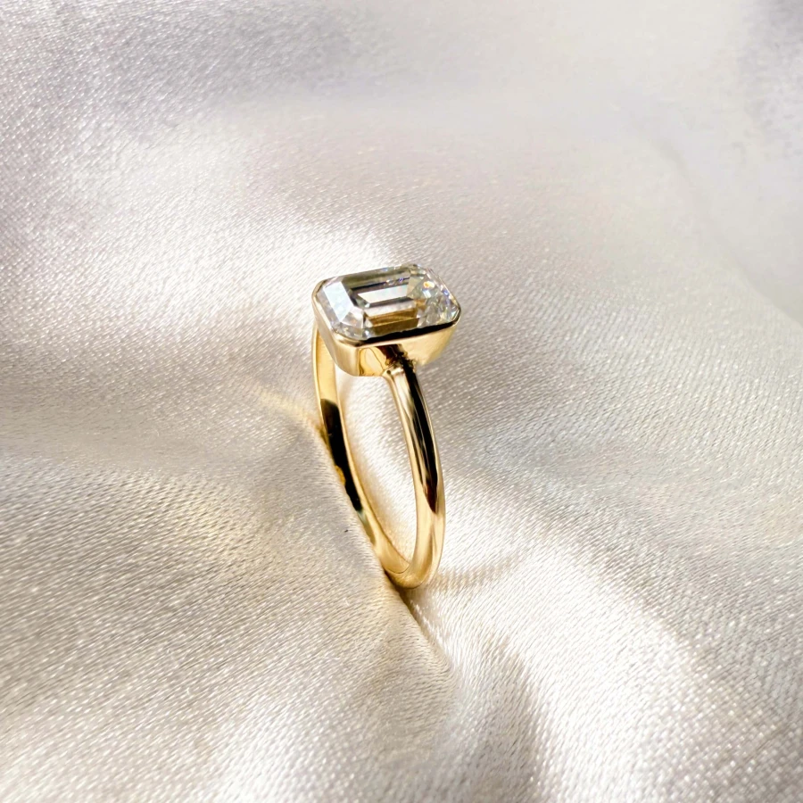 pierscionek-zareczynowy-bezel-moissanit-1ct-szlif-szmaragdowy-zblizenie-bok-zolte-zloto-stellar-hariets.jpg