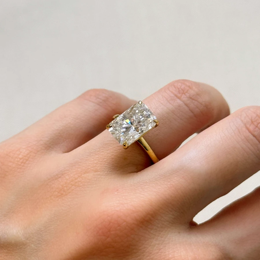 pierscionek-zareczynowy-royal-stones-moissanit-5ct-szlif-radiant-na-palcu-bok-zolte-zloto-avalon-hariets.jpg