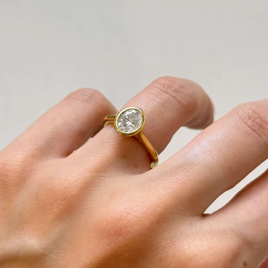 pierscionek-zareczynowy-bezel-moissanit-1-2ct-szlif-owalny-na-palcu-zblizenie-zolte-zloto-amora-hariets.jpg